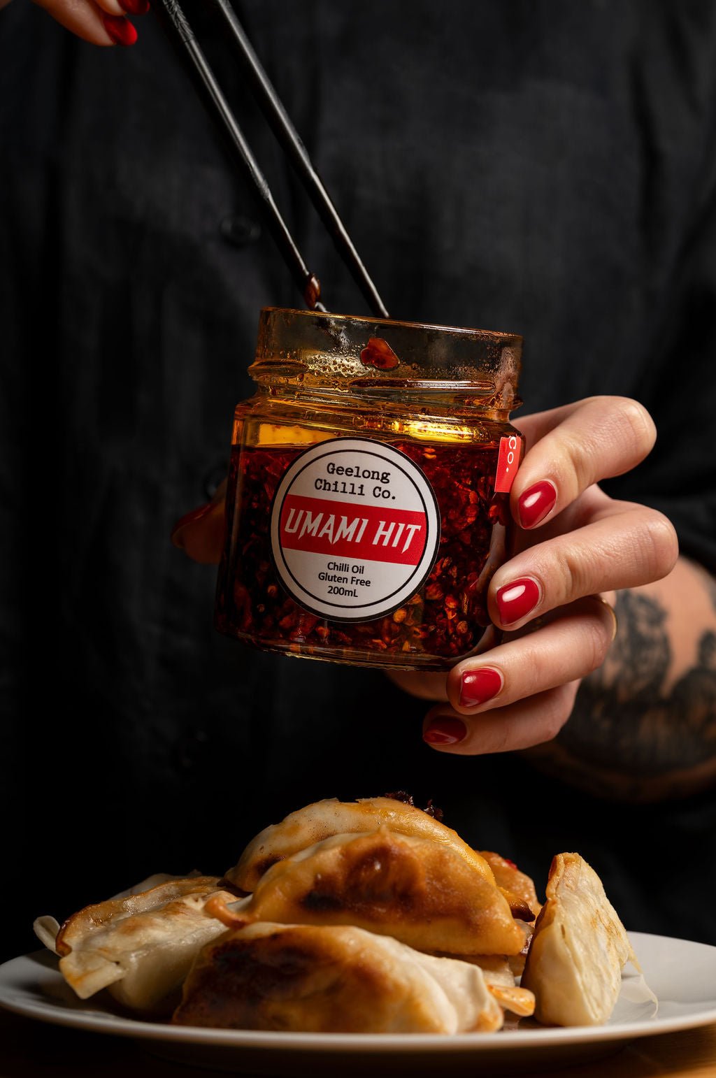 Person holding a jar of 'Umami Hit' with dumplings on a plate