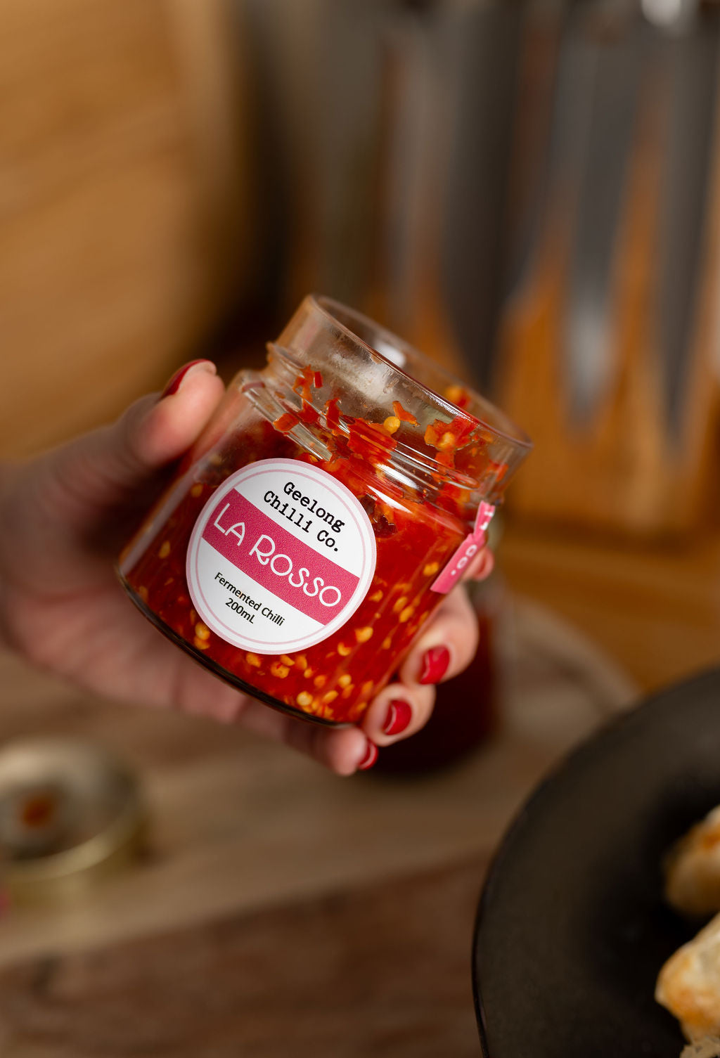 Hand holding a jar of La Rosso