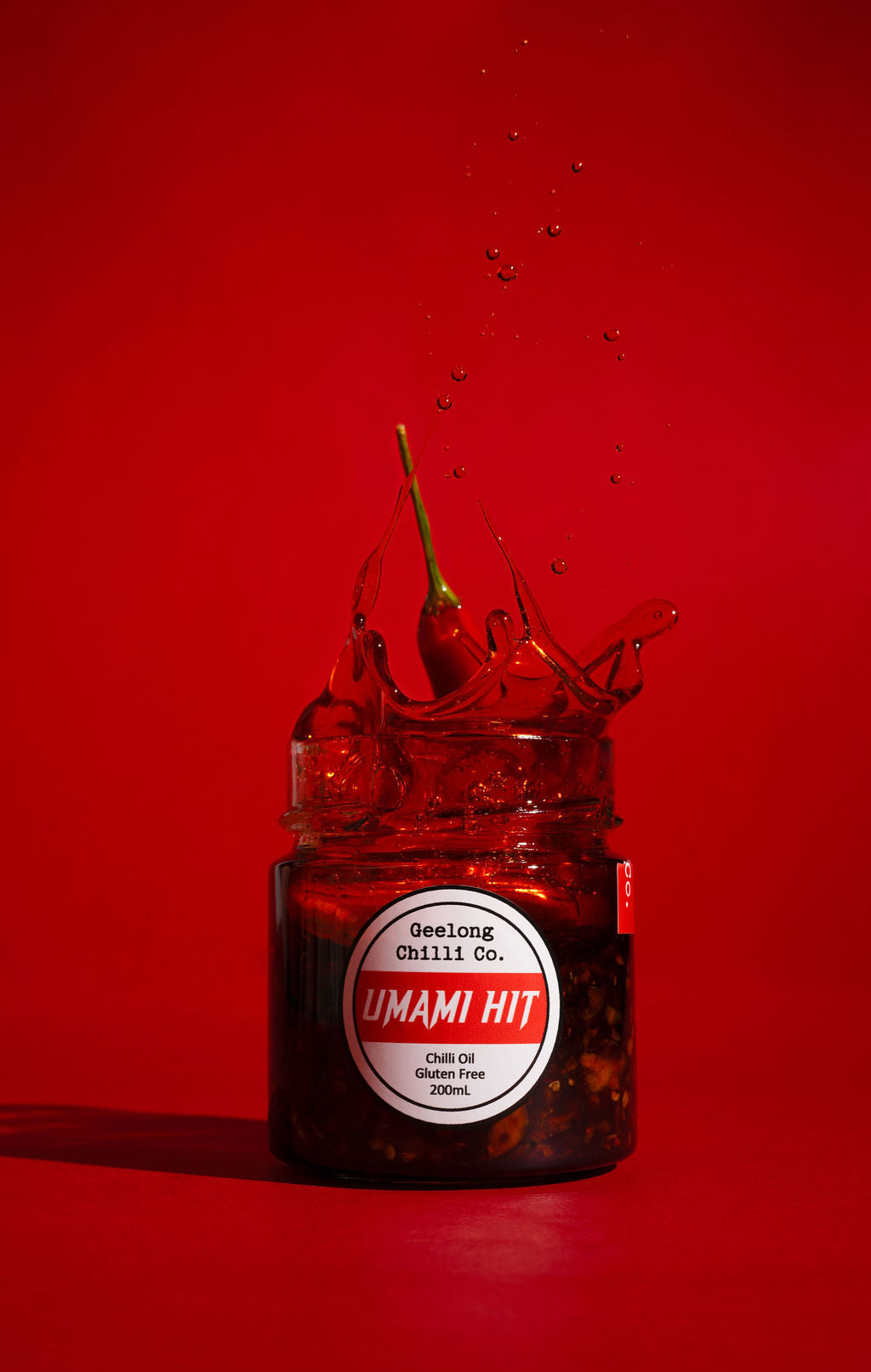 Jar of Umami Hit chili oil with a red background